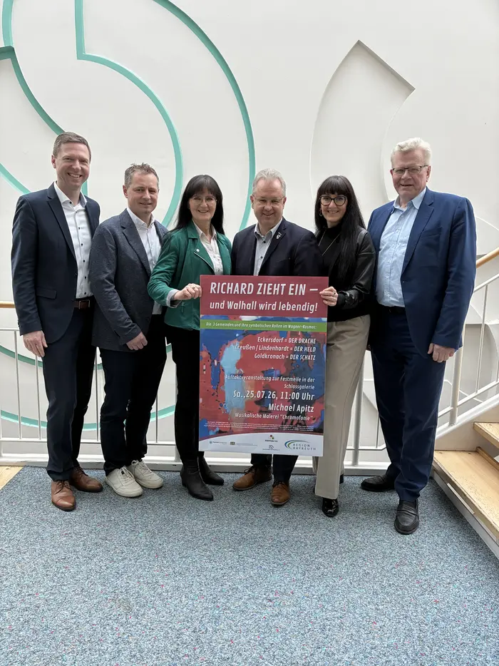 Gruppe von Menschen hält ein Plakat hoch