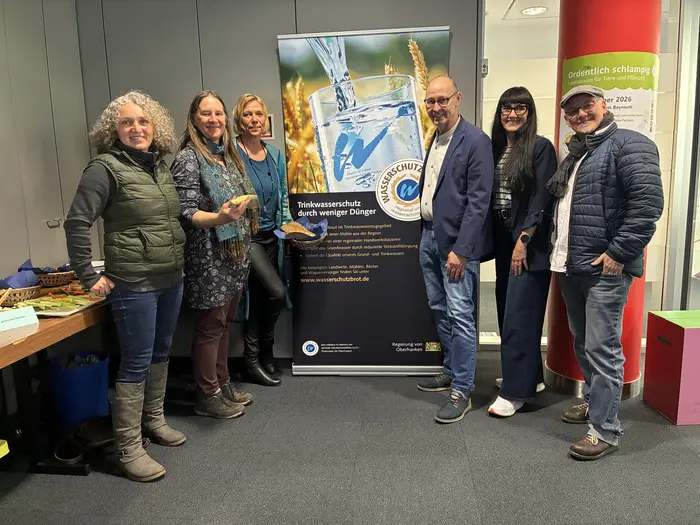 Menschengruppe steht vor einem Banner