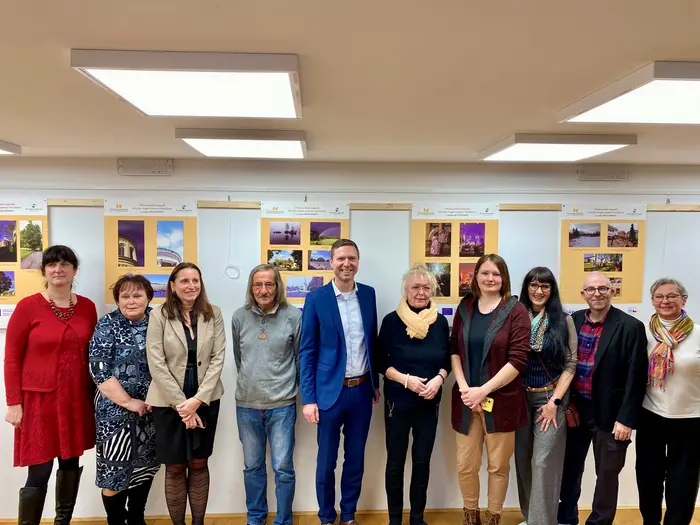 Eine Gruppe von Menschen steht vor Ausstellungsplakaten